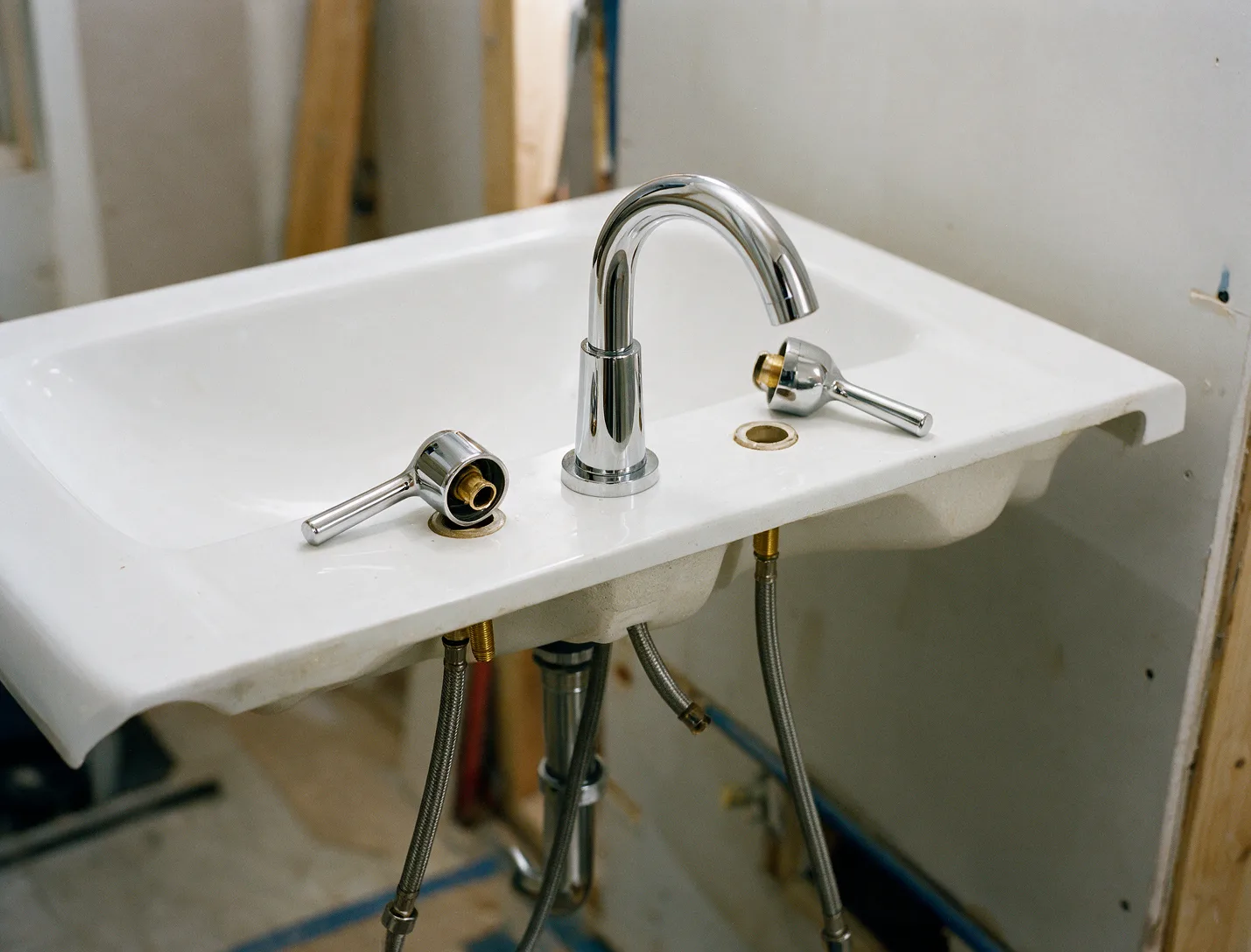 A new widespread chrome faucet being installed on a bathroom sink